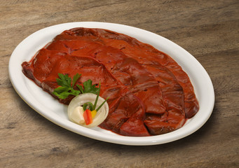 Raw meat selection on wooden cutting board with knife