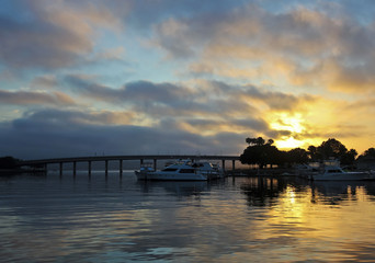 Fototapeta na wymiar A Gorgeous Sunrise Over a Bridge and Marina
