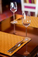 Two empty vine glasses in restaurant/Two empty wine glasses on a wooden table in a restaurant