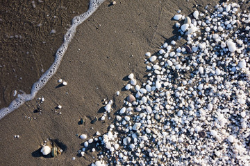 weisse Kieselsteine auf schwarzem Sand
