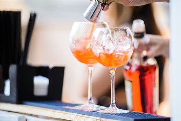 Barman preparing a cocktails/Barman added ingredients in a cocktail