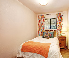 small bedroom with nice bedding and hardwood floor.