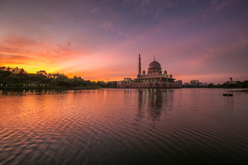 Fototapeta na wymiar beautiful sunrise At Putra Mosque, Putrajaya Malaysia with colorful clouds and reflection on the lake surface