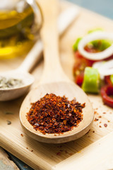 Paprika powder in wooden spoon and salad