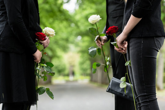 Familie erweist Verstorbenen letzte Ehre und steht im Spalier auf Friedhof bei Beerdigung