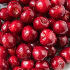 Bowl of red fresh cerries on a white background