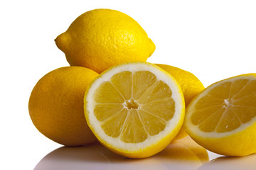 Lemons whole and halved shot front on on a white background