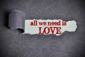 all we need is love word under torn black sugar paper