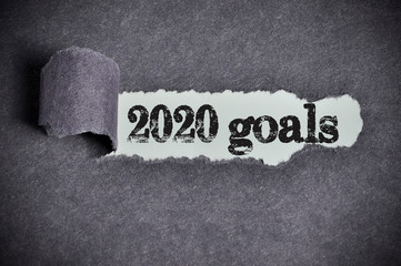 2020 goals word under torn black sugar paper