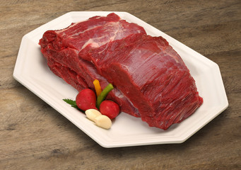 Raw meat selection on wooden cutting board with knife