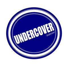 UNDERCOVER white stamp text on blue