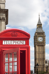 Fototapeta na wymiar London red telephone box booth with Big Ben clock tower in the background photo vertical