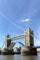 Fototapeta na wymiar Tower Bridge London England raised open opening with river thames City Hall building in the distance photo vertical
