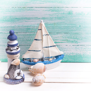 Decorative lighthouse,  sailing boats and marine items on wooden