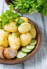Young boiled potatoes with dill, sausage, cucumber and parsley