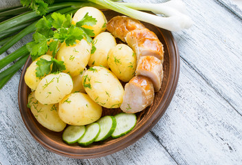 Young boiled potatoes with dill, sausage, cucumber and parsley