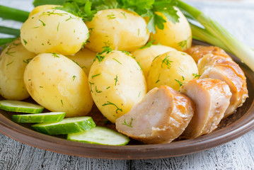 Young boiled potatoes with dill, sausage, cucumber, parsley and