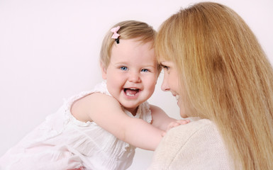 mother and her cute little baby girl having fun at home