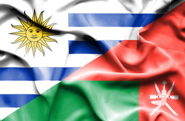 Waving flag of Oman and Uruguay