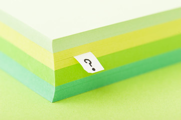 クエスチョンマークとメモ帳の束