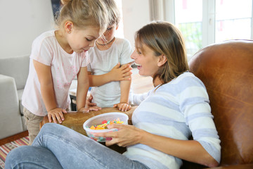 Kids getting candies from their mom © goodluz