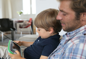 Daddy with son playing with video game player