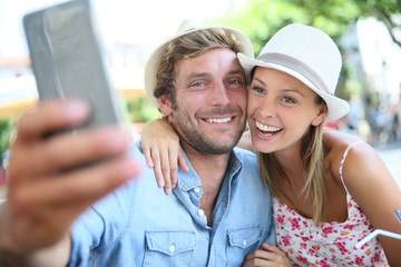 Couple of tourists taking selfie picture with smartphone