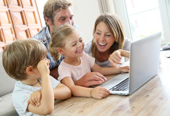 Parents with kids at home using laptop computer