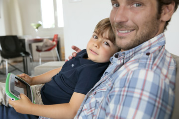 Daddy with son playing with video game player © goodluz