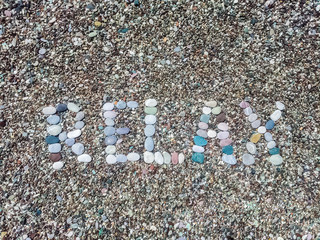 Relax word from stones on pebble beach