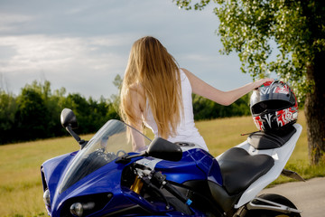 Naklejka na ściany i meble beautiful young woman with a motorcycle speed in nature