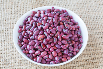 Adzuki bean or red bean in white bowl on wood background