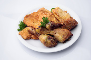 Chicken drumsticks and pork chops on plate
