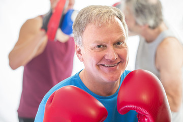 Senior man posing with boxing gloves