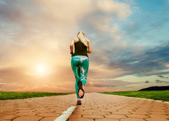 Young blonde girl evening jogging with great cloudscape