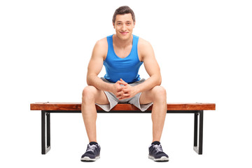 Young sportsman sitting on a wooden bench