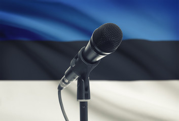 Microphone on stand with national flag on background - Estonia