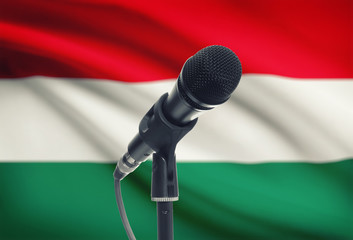 Microphone on stand with national flag on background - Hungary