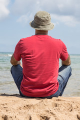 a man sitting by sea