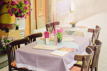 Cafe terrace in small European city at sunny summer day