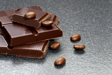 Dark chocolate and coffee bean on a stone table 

