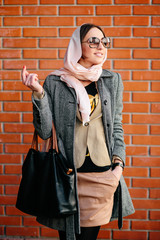 girl posing on a background of red brick wall