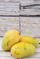 Exotic mango fruits over weathered wooden background