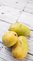 Exotic mango fruits over weathered wooden background