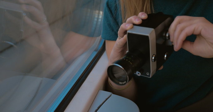 Woman using retro video camera to shoot the way