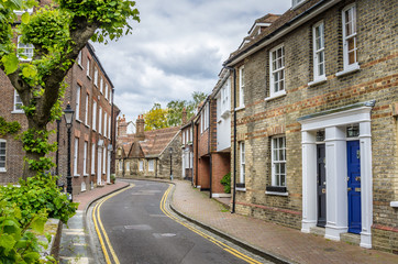 Fototapeta premium Narrow Street Lined with Terraced Houses and Cloudy Sky