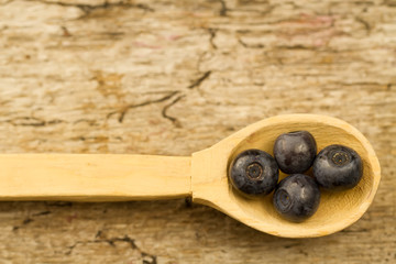 fresh blueberries in spoon on wooden background, close-up