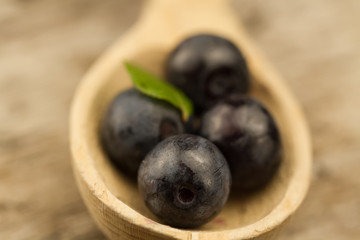 fresh blueberries in spoon on wooden background, close-up