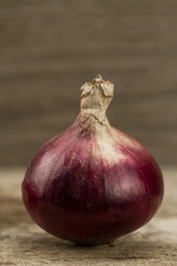 fresh red onions on wooden background, macro