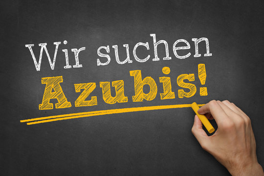 Hand schreibt Text "Wir suchen Azubis" auf Kreidetafel